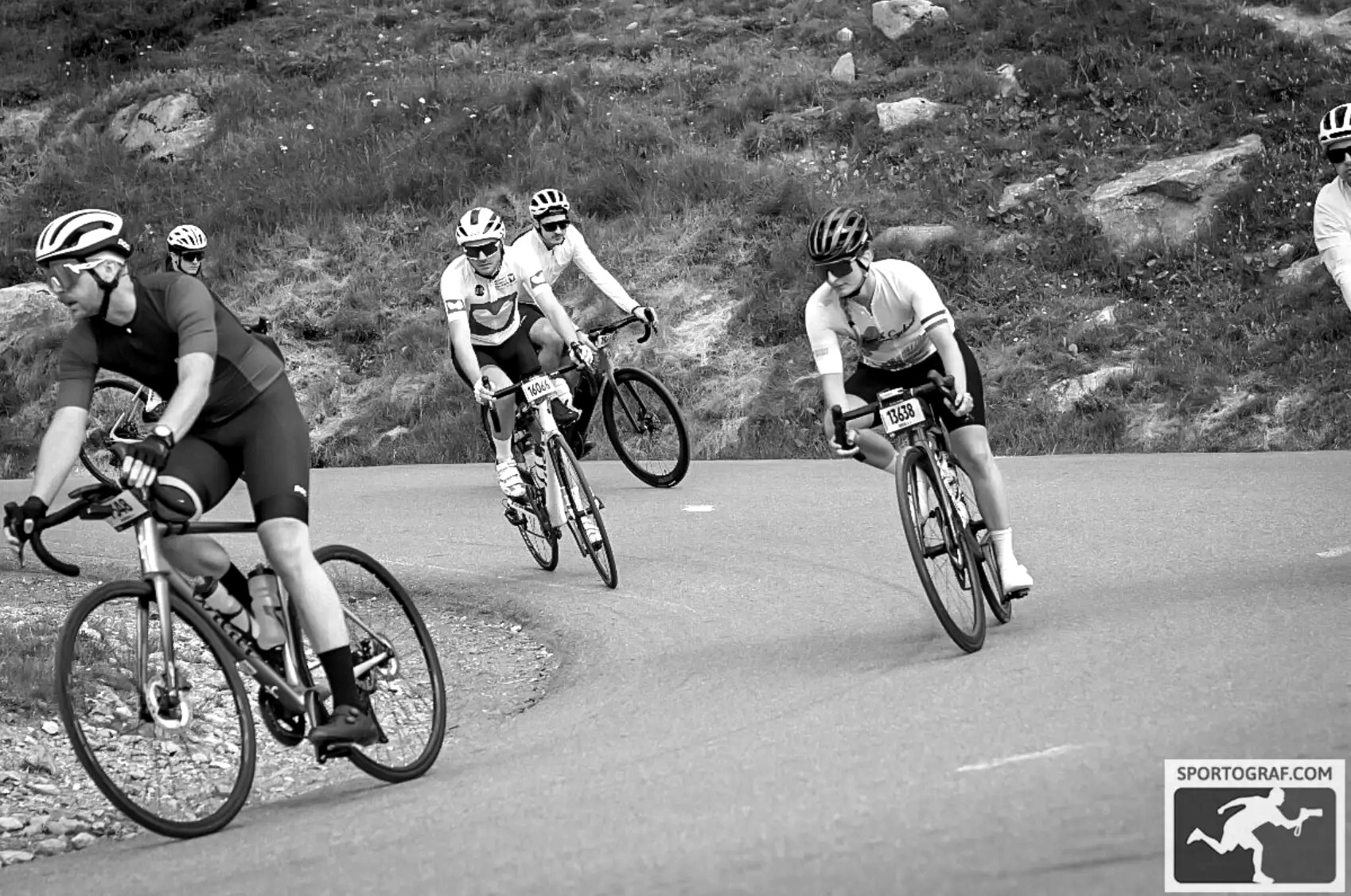 Riders cornering on a mountain road during a mass-participation cycling event