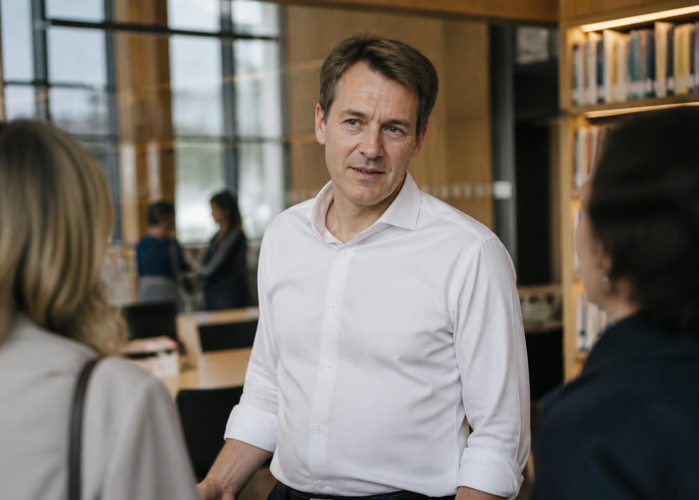 Eric Wing in conversation in a modern library